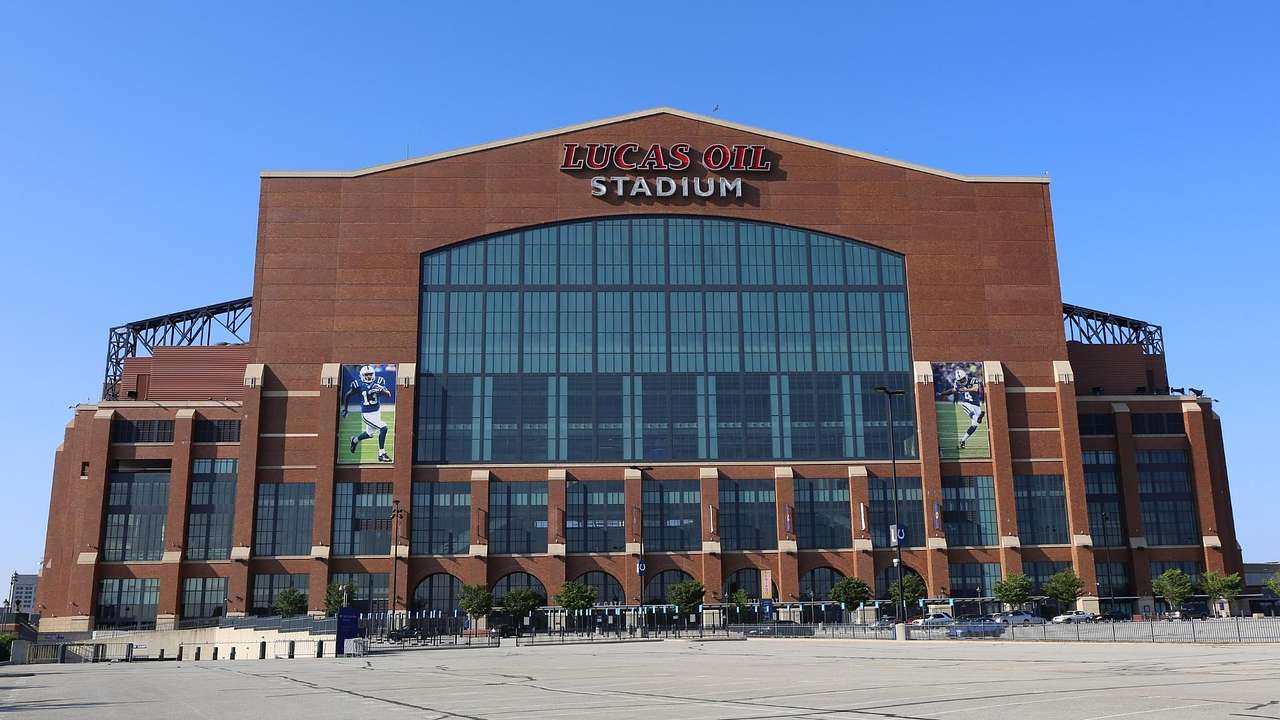A red brick building with a large window and a sign that says "Lucas Oil Stadium"