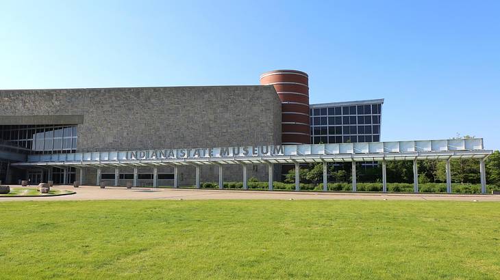 A modern gray building with a walkway and green grass outside