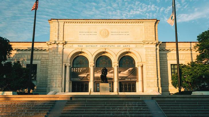 A Beaux-Arts building with three arches and a statue and staircase in front