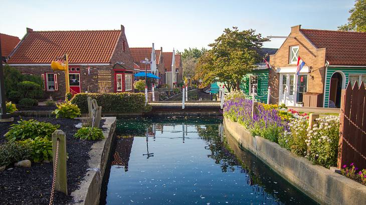 A canal between hut-shaped houses under a clear sky