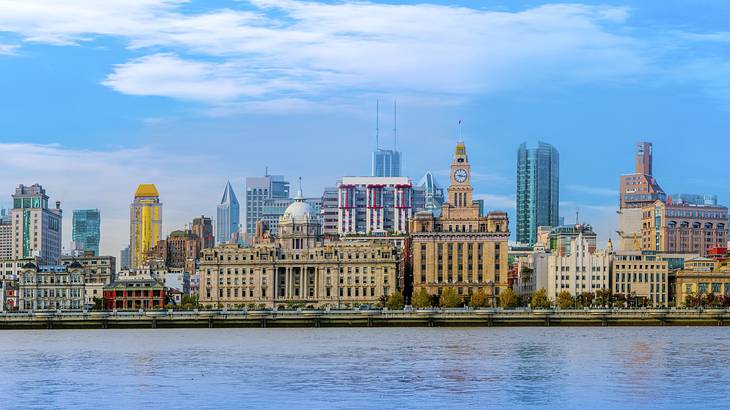 A city skyline of modern and old historical buildings by the riverfront on a nice day