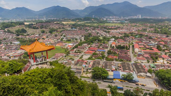 Top view of a city with buildings, houses, vegetation, and mountains