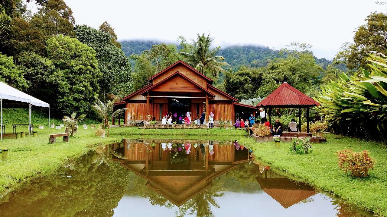 A wooden hut next to greenery and a pond