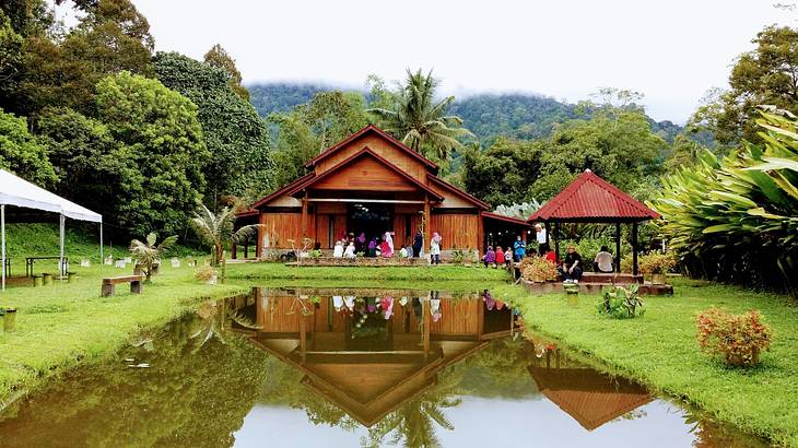 A wooden hut next to greenery and a pond