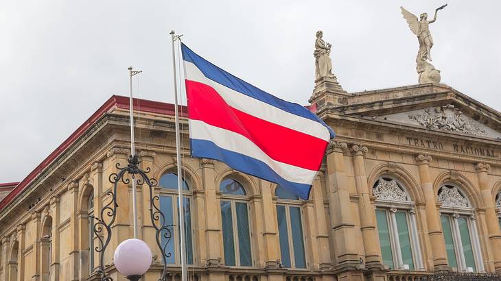 A stone building with statues on top and a Costa Rican flag