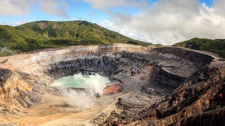 Lush mountain and a volcano with a crater filled with green-blue color rainwater