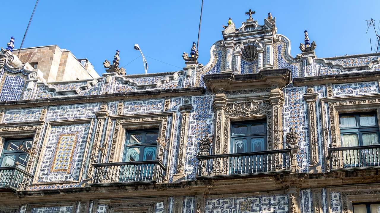 A regal palace-style building with balconies and white and blue tiles on its walls
