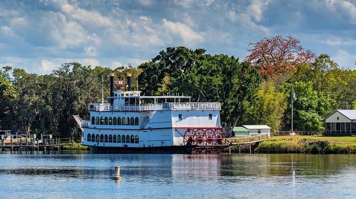 A riverboat docked by the riverside near trees