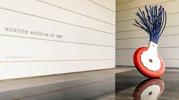 A modern sculpture resembling a typewriter eraser in the middle of a white building