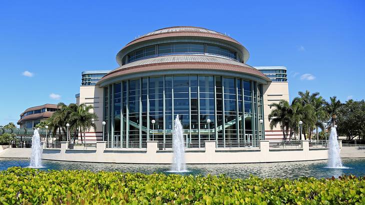 A dome-shaped structure with large glass panels with fountains in front