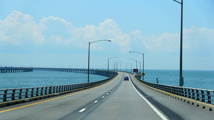 A long bridge surrounded by a large body of water