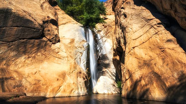 A waterfall flowing over rocks into a pool below