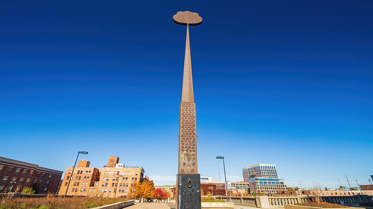 A tall obelisk-like structure in the middle of a paved area