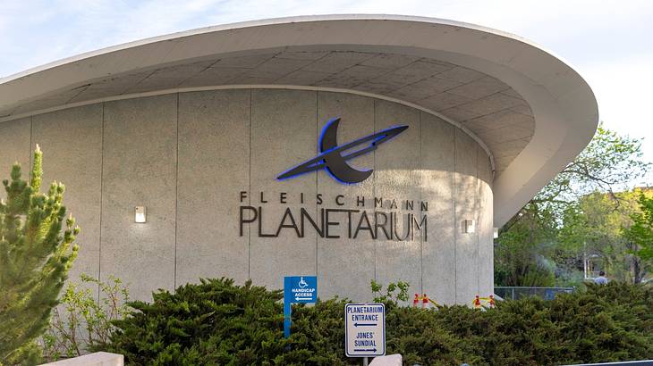 A curved building with a sign that says "Fleischmann Planetarium"