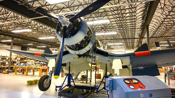 A vintage plane in a brightly-lit hangar