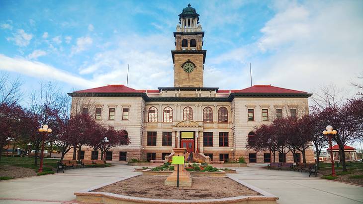 A building with a red roof and tower and a path in front of it