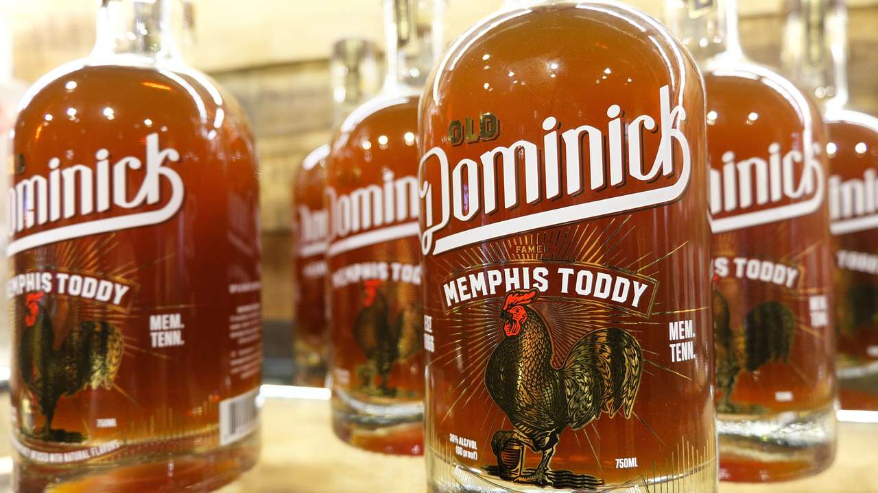 Bottles of alcohol with a rooster image and an "Old Dominick Memphis Toddy" label