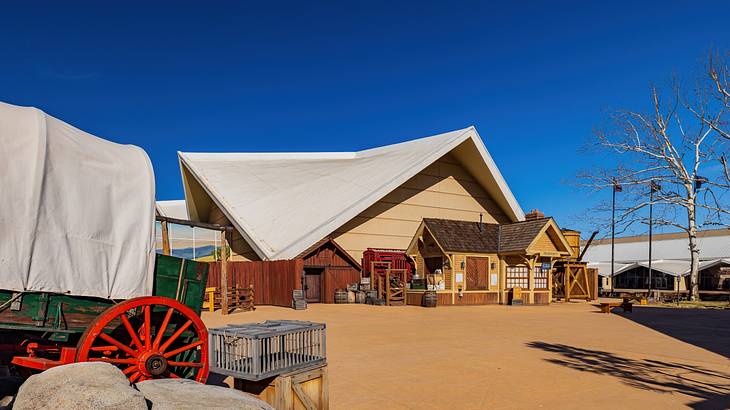 A building surrounded by a covered wagon and other structures