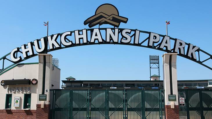 A sign that says "Chukchansi Park" over a gate next to a blue sky
