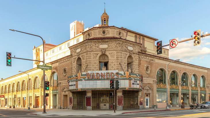 An old-fashioned theater building with a sign that says "Warnors Theatre"