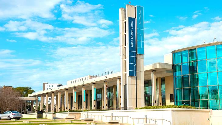 A modern building with columns and glass windows under a blue sky