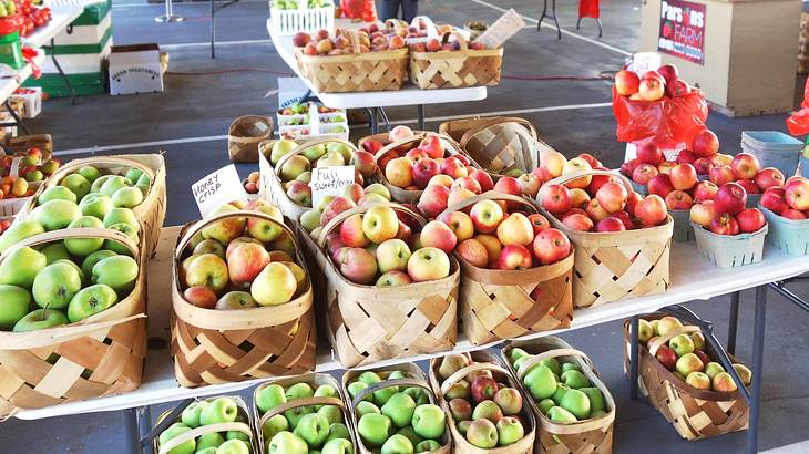 A market with stalls that have apples in baskets