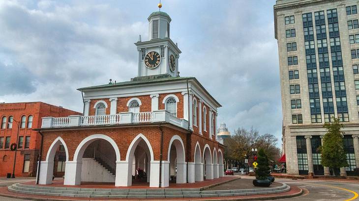 A red brick and white building with archways and a clock tower