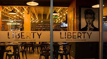 The glass front of a restaurant with a "Liberty Food & Wine Exchange" sign