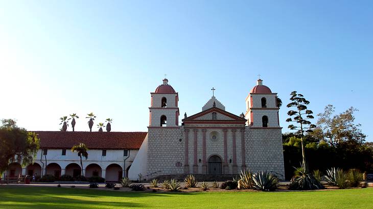 An old church and a large front lawn with trees and plants on a nice day