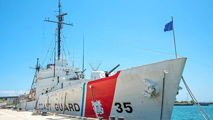 A white warship with "Coast Guard 35" text against a blue sky