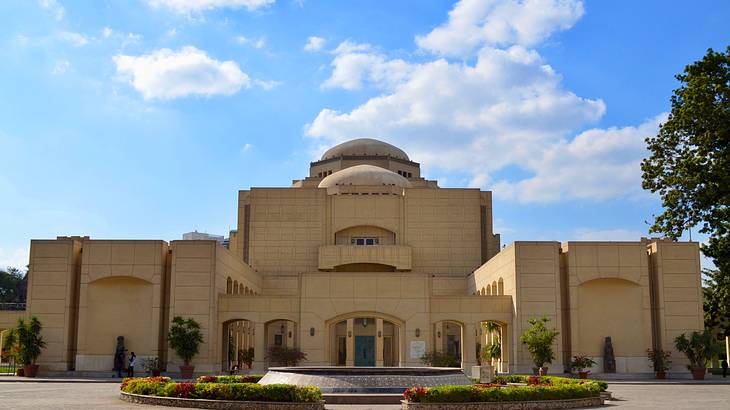 A post-modern-style building with a dome top in the middle near a fountain