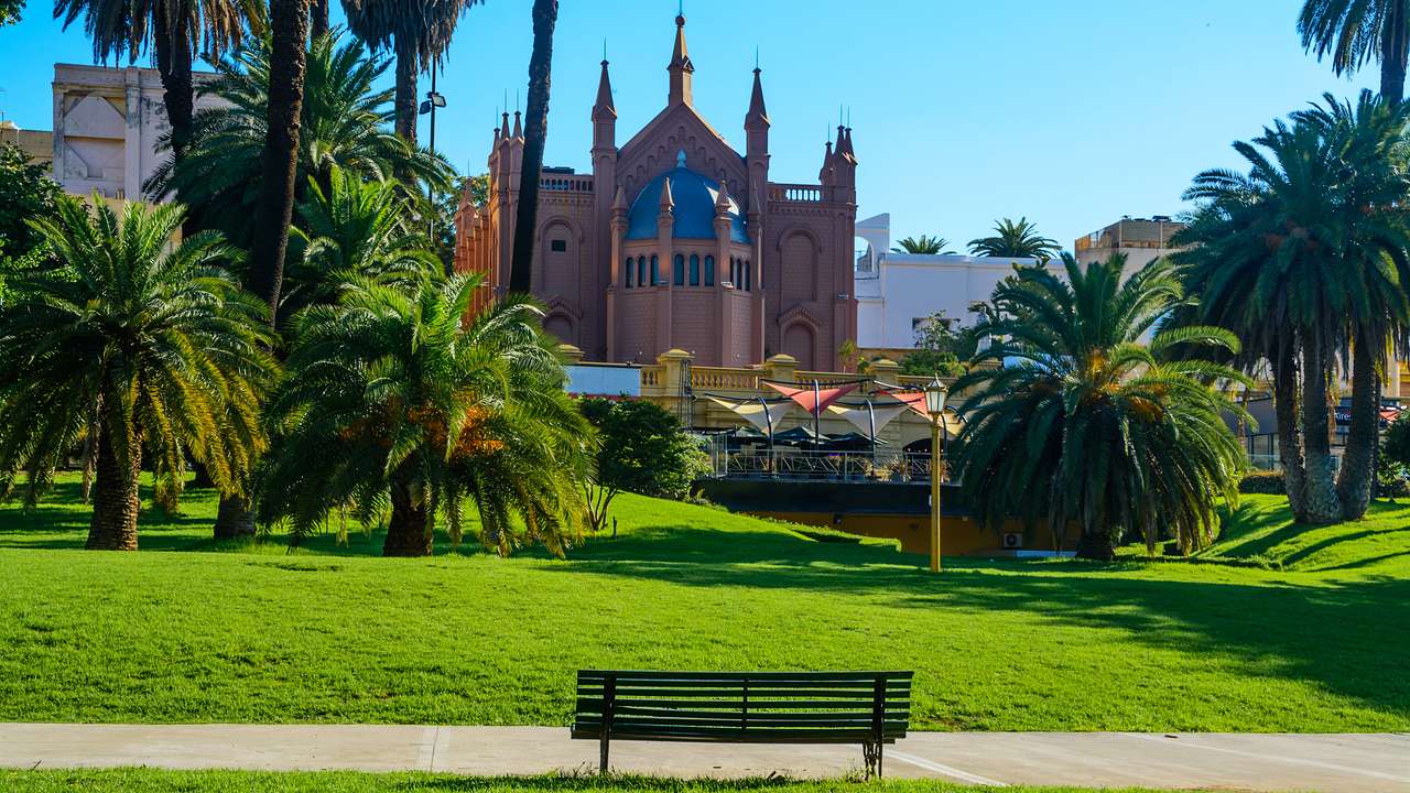 A park in front of a cathedral under a blue sky