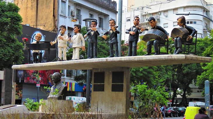 A bust statue and sculptures of men playing instruments