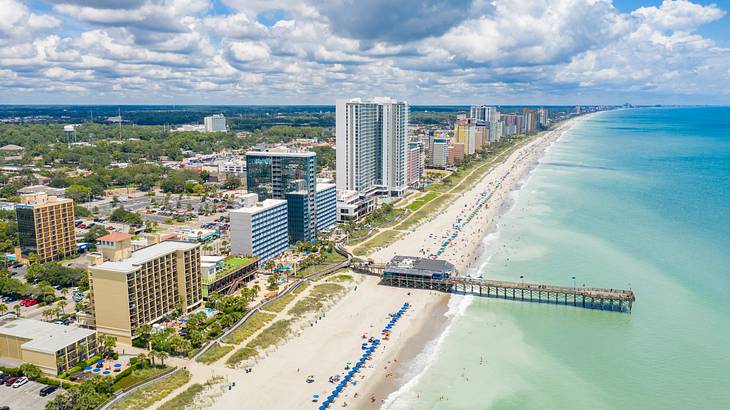 Buildings near a boardwalk, sand, and a large body of water