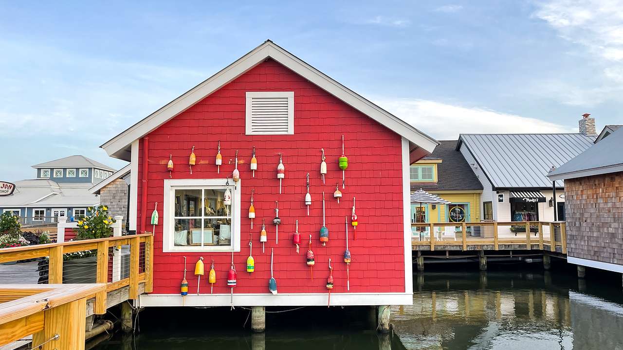 A red house with hanging fishing rods near a body of water