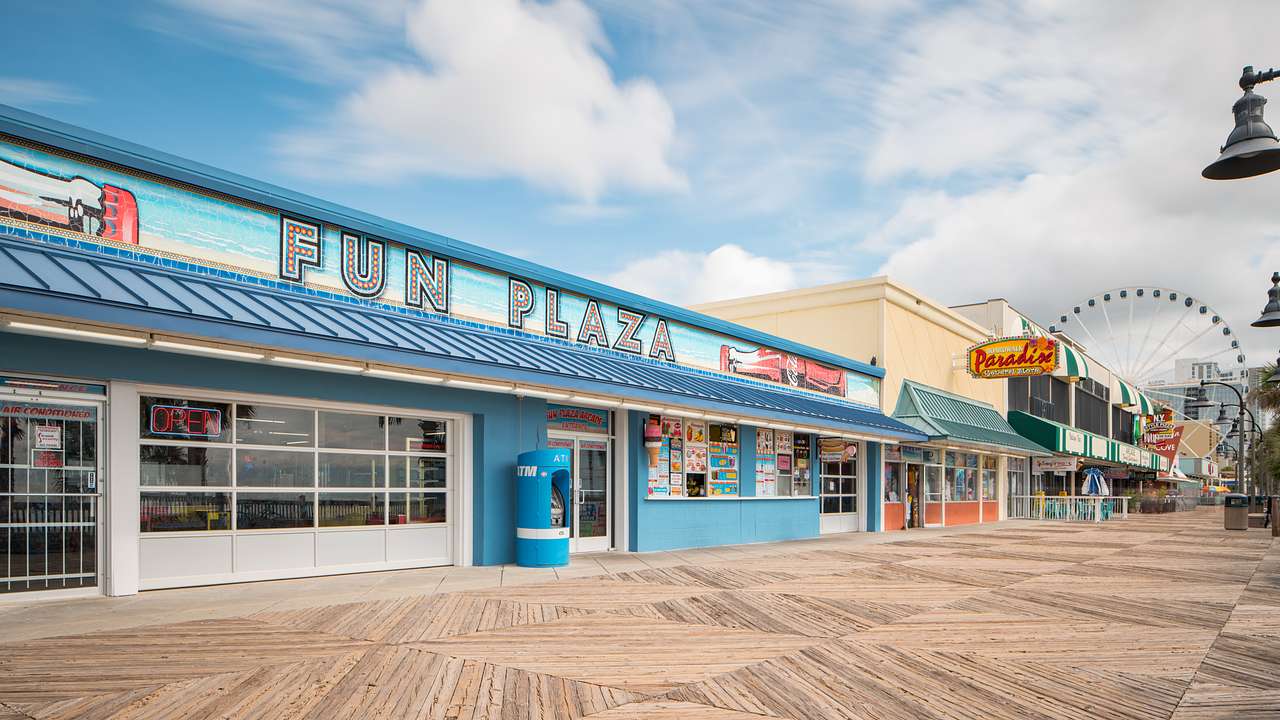 A building with a sign saying Fun Plaza near a tiled boardwalk
