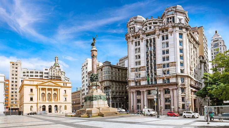 A square with a column and historical buildings around it on a nice day