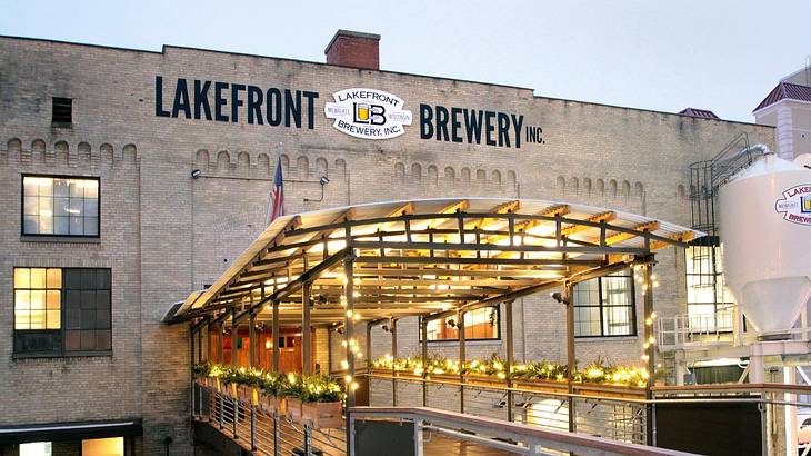 A building with a "Lakefront Brewery" sign and an illuminated path leading to it
