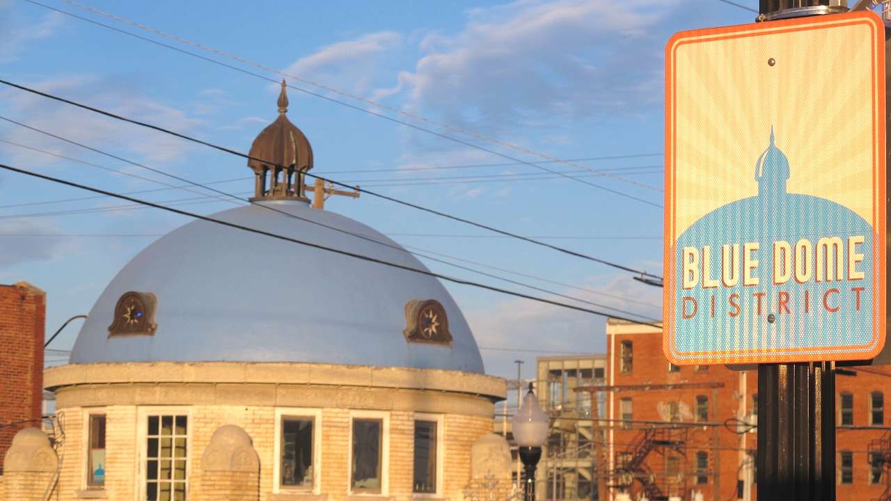 A building with a blue dome next to a sign that says "Blue Dome District"