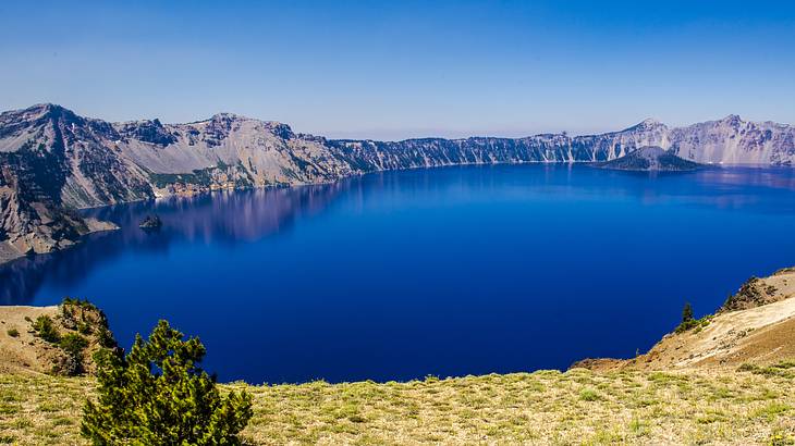 Aerial view of a lake with deep blue water in a volcano crater against a clear sky