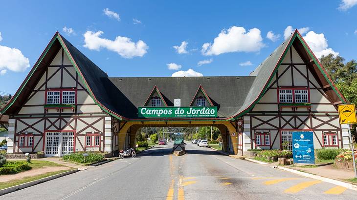 Two Swiss-style buildings connected by a bridge and a "Campos do Jordão" sign