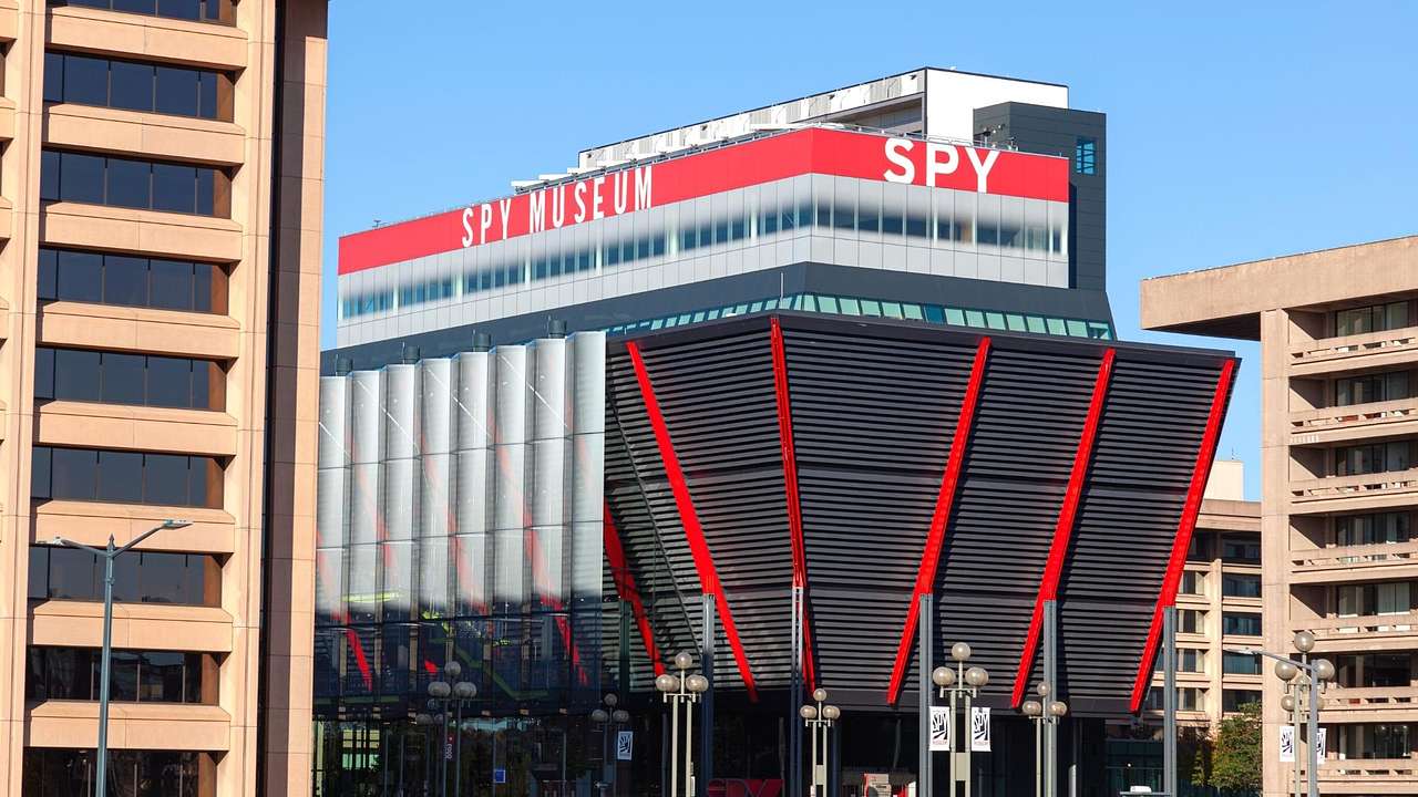 A modern red and black building with a "Spy Museum" sign