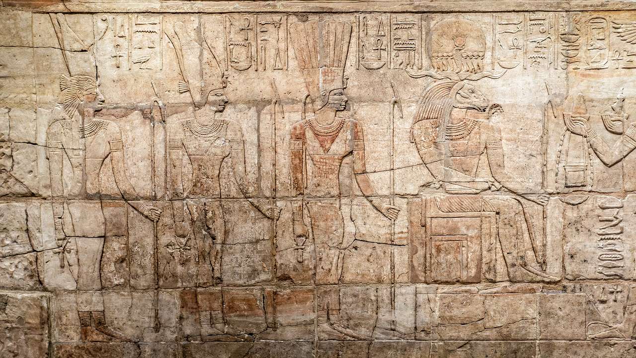 A large wall carved with Eqyptian drawings and symbols
