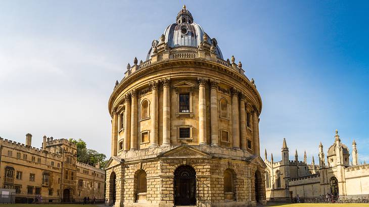 A dome building with arched doorways and windows in the middle of a courtyard