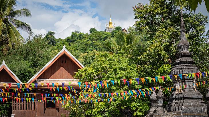 Stone structures with festival garlands hanging on them and a temple in the back