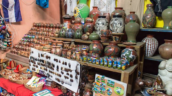 A souvenir shop with clothes, earrings, colourful clay pots, magnets, and statues