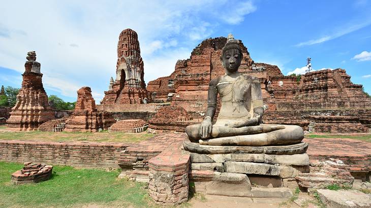 Ancient temple ruins with a Buddha statue in front