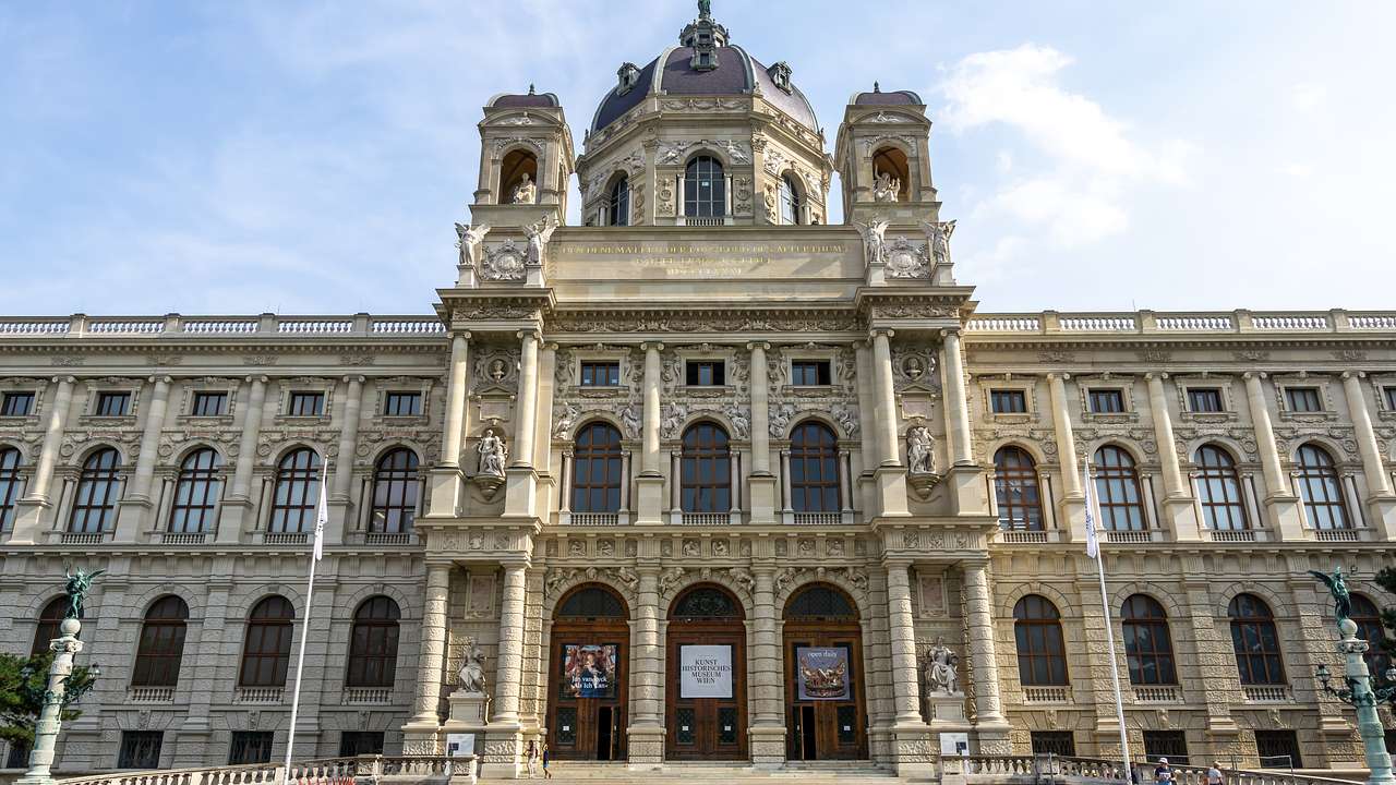 A palatial building with a dome in the center and several statues on its exterior