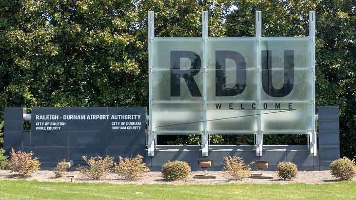 A large sign that says "Raleigh–Durham Airport Authority" next to greenery