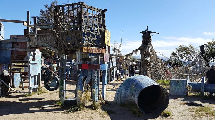 A playground made of recycled materials with nets, swings, and forts